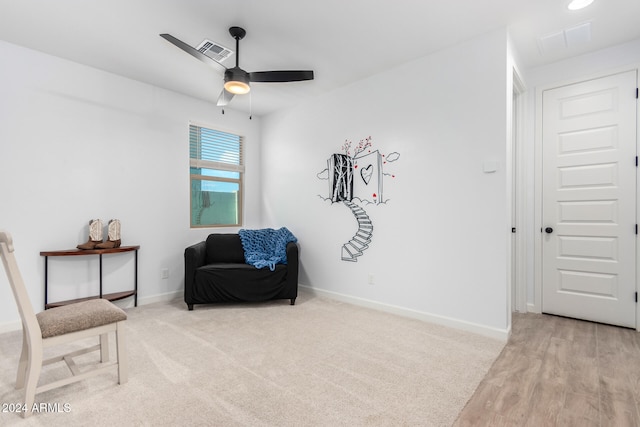 living area featuring light hardwood / wood-style floors and ceiling fan