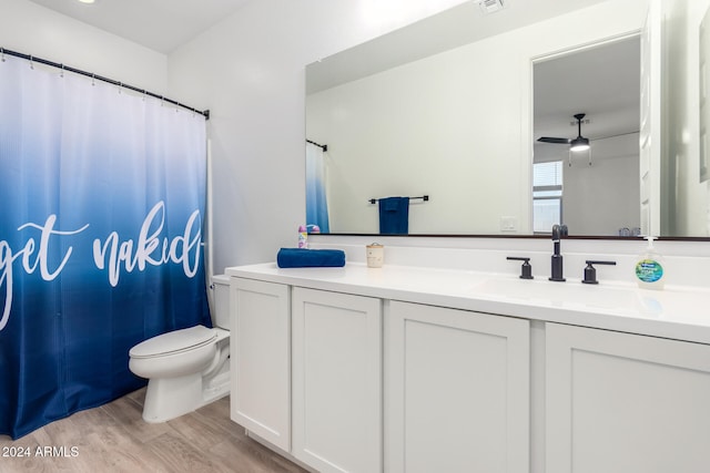 bathroom featuring toilet, vanity, hardwood / wood-style flooring, and ceiling fan