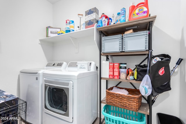 clothes washing area with washing machine and clothes dryer and wood-type flooring