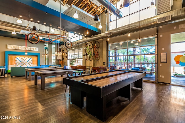 recreation room featuring hardwood / wood-style flooring, billiards, and a towering ceiling