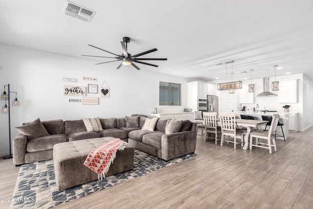 living room featuring ceiling fan and light wood-type flooring