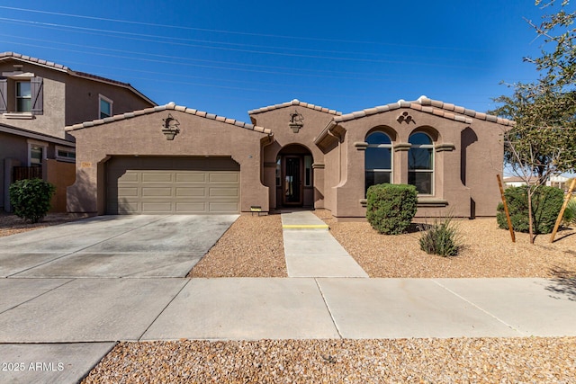 mediterranean / spanish home with concrete driveway, a tile roof, an attached garage, and stucco siding