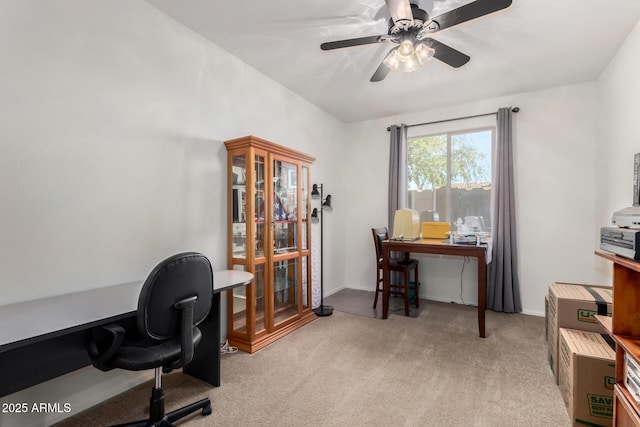 office area featuring light carpet, a ceiling fan, and baseboards