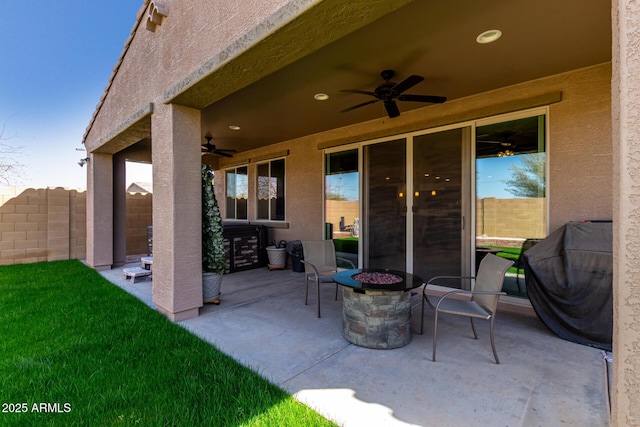 view of patio featuring fence, a fire pit, area for grilling, and ceiling fan