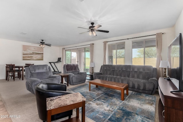 living area with a ceiling fan and carpet