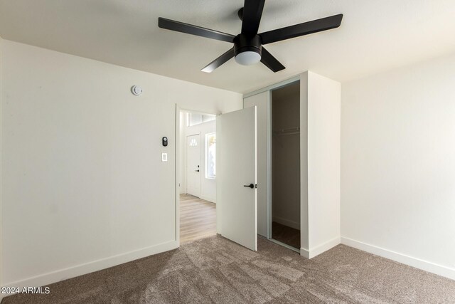 unfurnished bedroom featuring carpet, ceiling fan, and a closet