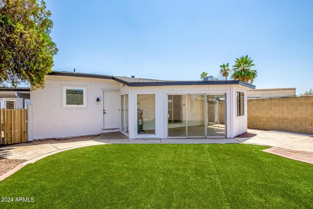 back of property with a patio area and a lawn