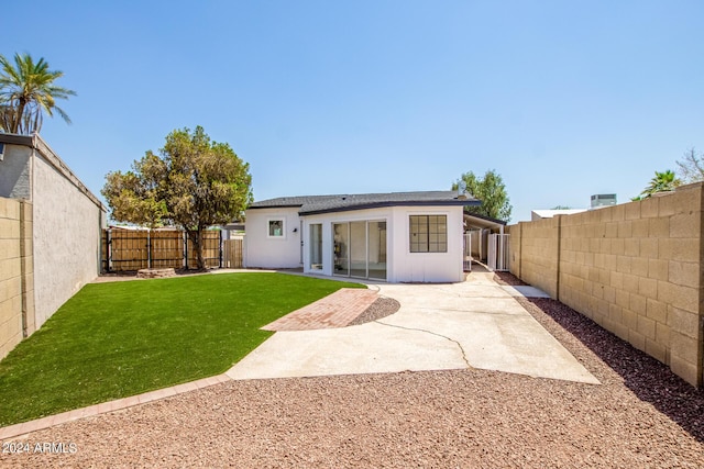 back of property featuring a patio and a lawn