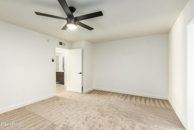 carpeted spare room featuring ceiling fan