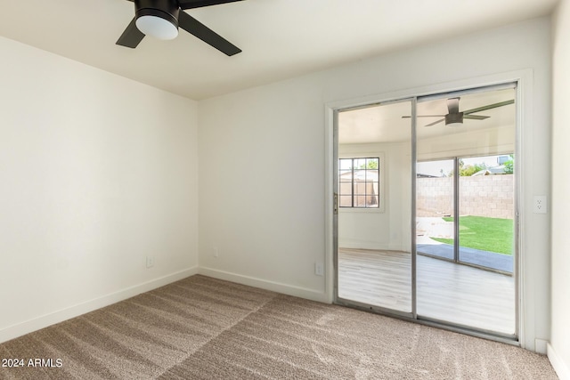 carpeted spare room featuring ceiling fan