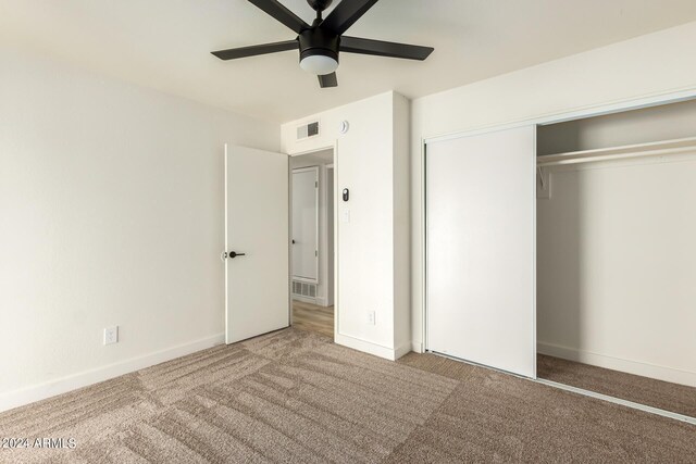 unfurnished bedroom featuring light carpet, a closet, and ceiling fan