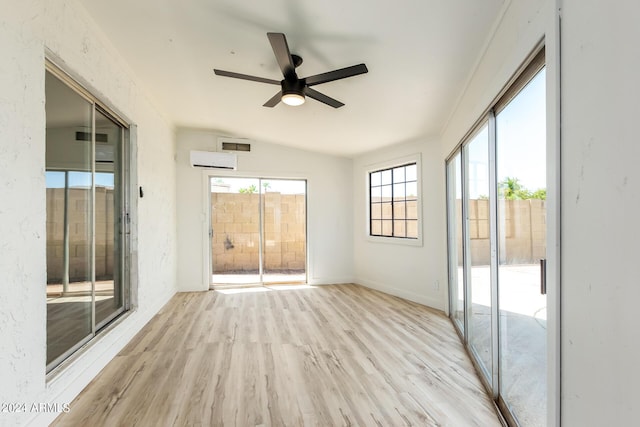 unfurnished sunroom featuring vaulted ceiling, an AC wall unit, and ceiling fan