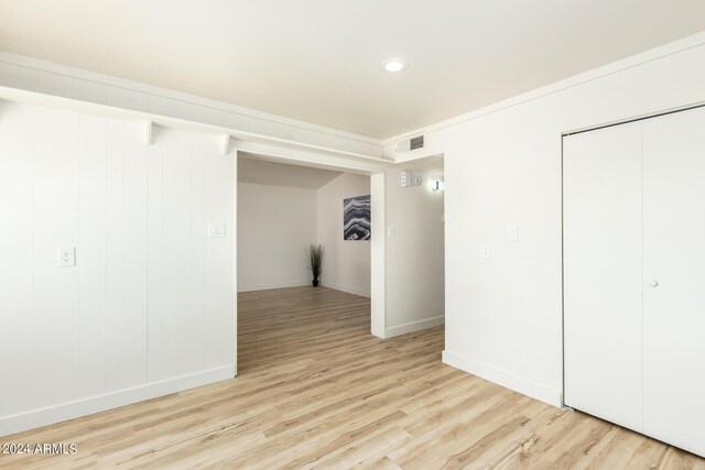 unfurnished bedroom with light hardwood / wood-style floors and a closet