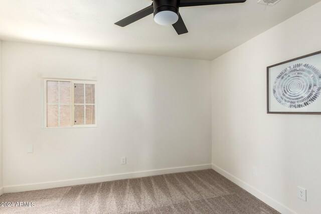 carpeted spare room featuring ceiling fan