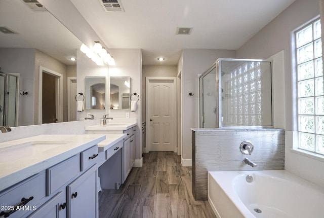 1950 W Park Pl, Chandler, AZ 85224 - bathroom featuring a shower stall, double vanity, a garden tub, and wood finished floors