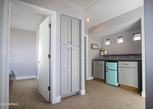 1950 W Park Pl, Chandler, AZ 85224 - kitchen with light colored carpet, baseboards, dark countertops, freestanding refrigerator, and gray cabinetry