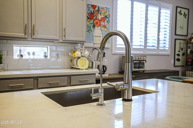 1950 W Park Pl, Chandler, AZ 85224 - kitchen with light stone countertops, backsplash, and a sink