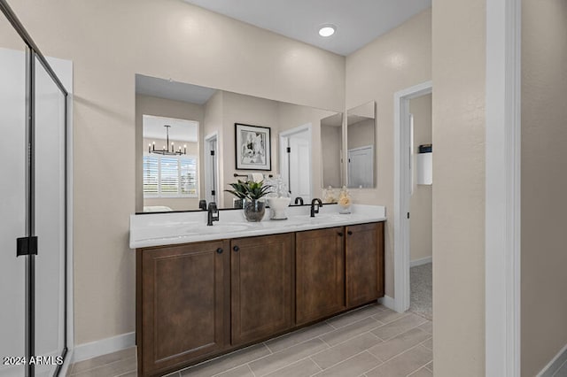 bathroom with vanity, a chandelier, and an enclosed shower