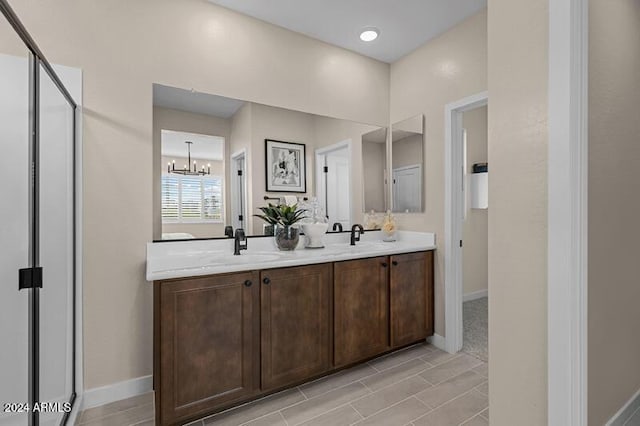 9243 E Sector Dr, Mesa, AZ 85212 - bathroom with baseboards, an inviting chandelier, double vanity, and a sink
