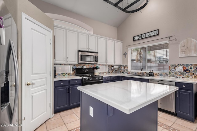 kitchen with sink, appliances with stainless steel finishes, backsplash, a center island, and white cabinets