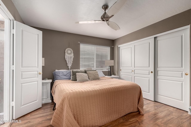 bedroom with ceiling fan, a closet, and light wood-type flooring