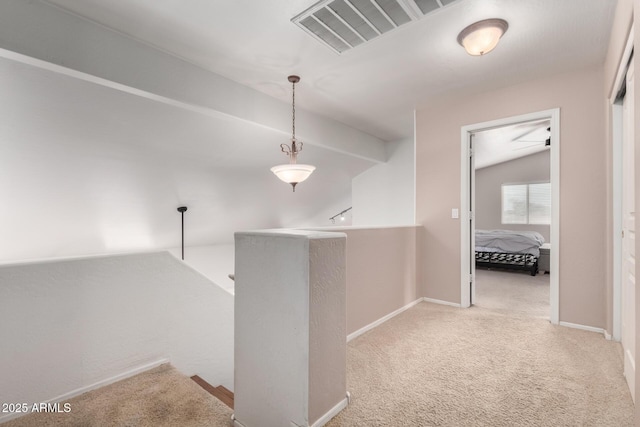 corridor with vaulted ceiling and light carpet