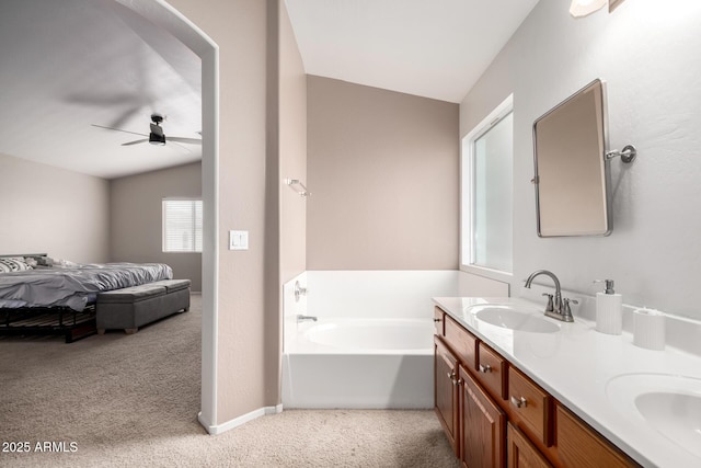 bathroom featuring vaulted ceiling, ceiling fan, vanity, and a bathtub