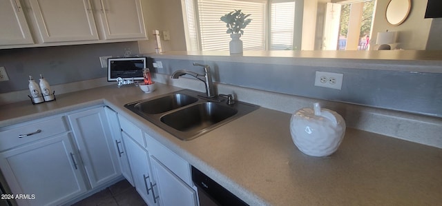 kitchen featuring tile patterned flooring, white cabinetry, and sink