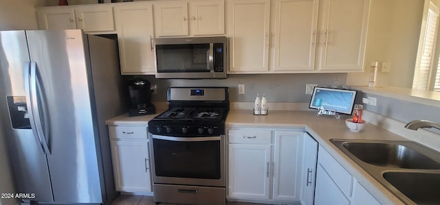 kitchen with white cabinets, stainless steel appliances, and sink