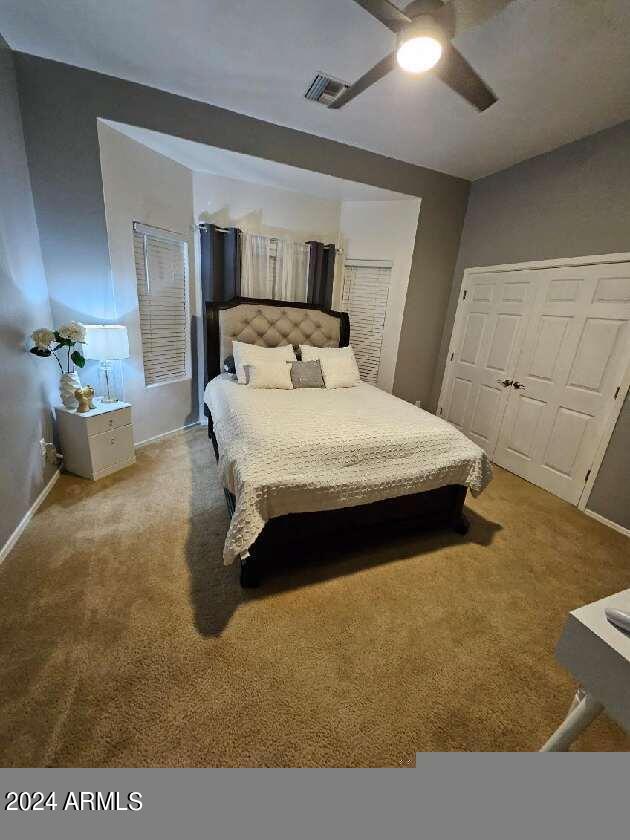 bedroom featuring carpet, ceiling fan, and a closet