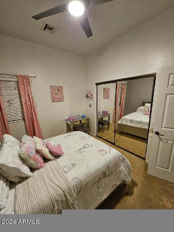 bedroom featuring ceiling fan, a closet, and carpet