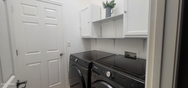 washroom featuring cabinets and washing machine and clothes dryer