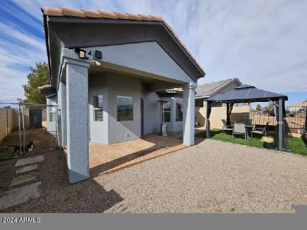 rear view of property with a gazebo and a patio area