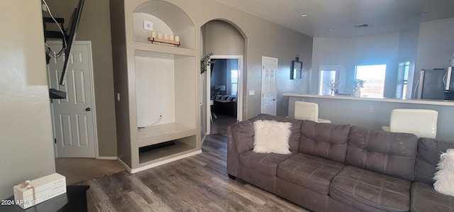 living room featuring built in features and dark wood-type flooring