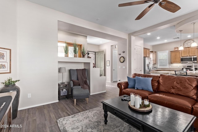 living room with dark wood-type flooring, ceiling fan, a healthy amount of sunlight, and sink