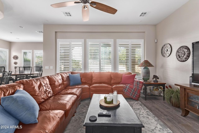 living room featuring ceiling fan and dark wood-type flooring