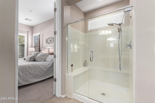 bathroom with tile patterned floors and a shower with door