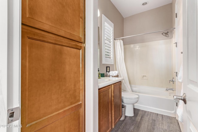 full bathroom featuring toilet, vanity, hardwood / wood-style flooring, and shower / tub combo with curtain