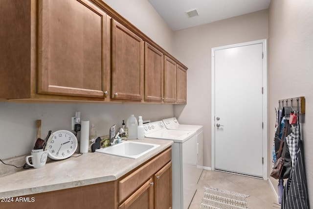 clothes washing area with light tile patterned flooring, cabinets, independent washer and dryer, and sink