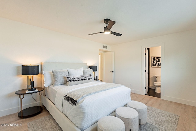 bedroom with ceiling fan, ensuite bathroom, and light hardwood / wood-style flooring