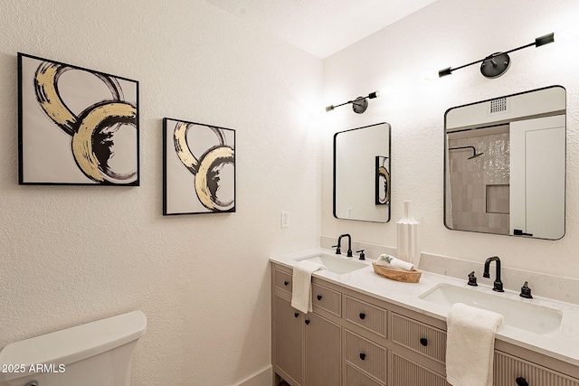 bathroom with walk in shower, vanity, and toilet