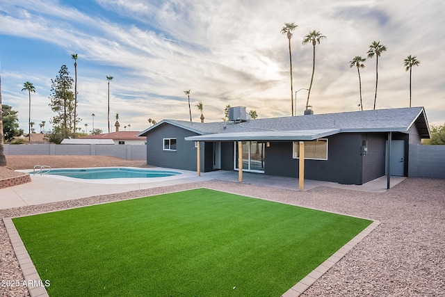 back of house with a fenced in pool, a yard, central AC, and a patio