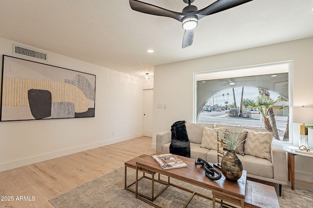 living room with wood-type flooring and ceiling fan