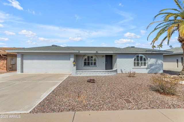 single story home with concrete driveway, brick siding, and an attached garage