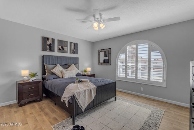 bedroom with a ceiling fan, light wood-type flooring, and baseboards