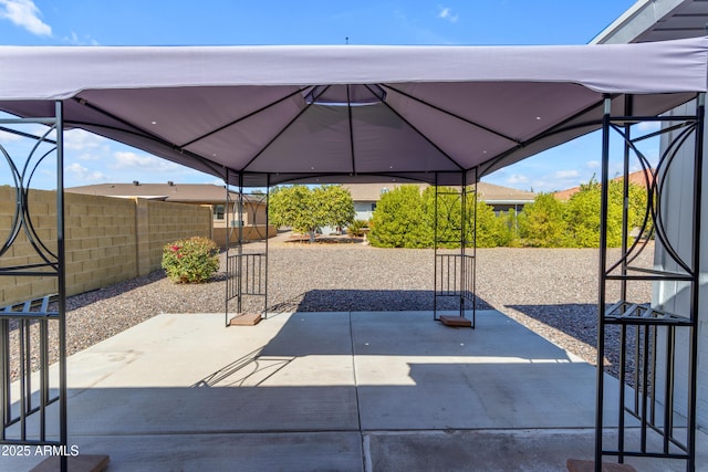 view of patio featuring fence and a gazebo