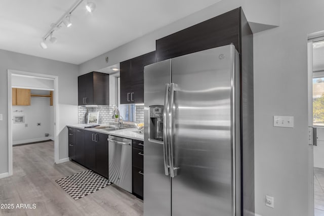 kitchen with backsplash, modern cabinets, stainless steel appliances, and a sink