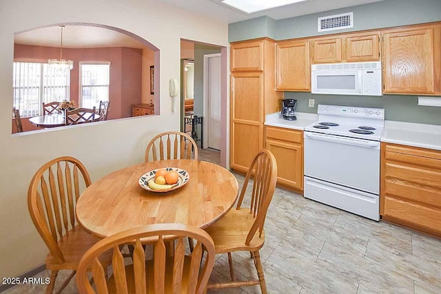 kitchen with pendant lighting, light brown cabinetry, white appliances, and a chandelier