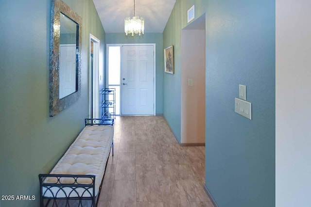 doorway to outside with lofted ceiling and a notable chandelier