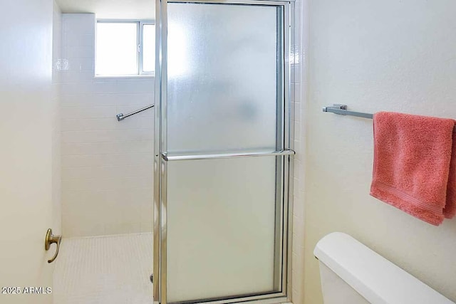 bathroom with an enclosed shower and toilet